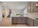 Stylish kitchen with gray cabinets, stainless steel appliances, and an open layout, seamlessly connecting to the living area at 16119 Paynes Mill Dr, Bradenton, FL 34211