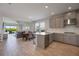 Open-concept kitchen with sleek gray cabinetry, stainless steel appliances, and a bright dining area at 16119 Paynes Mill Dr, Bradenton, FL 34211