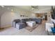 Large living room area with a ceiling fan, sectional sofa, large TV, and view of the kitchen at 16119 Paynes Mill Dr, Bradenton, FL 34211