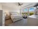 Sunlit main bedroom features a large bed, windows, a ceiling fan, and neutral decor at 16119 Paynes Mill Dr, Bradenton, FL 34211