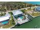 Beautiful aerial view of waterfront home featuring a pool, dock, and lush tropical landscaping at 1918 Massachusetts Ave, Englewood, FL 34224