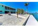 The home features a dock, tropical foliage, an outdoor living space, and easy access to the water at 1918 Massachusetts Ave, Englewood, FL 34224