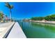 A long, light-colored wooden dock sits on a waterway with lush vegetation in the area at 1918 Massachusetts Ave, Englewood, FL 34224