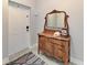 Charming entryway with a decorative wooden dresser, mirror, and tile flooring, offering a warm and inviting welcome at 1918 Massachusetts Ave, Englewood, FL 34224