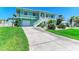 The home boasts a well-manicured lawn, two-car garage, and easy access via a white staircase at 1918 Massachusetts Ave, Englewood, FL 34224