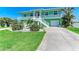 Charming coastal home featuring a lush green lawn, two-car garage, and a lovely two-story floorplan at 1918 Massachusetts Ave, Englewood, FL 34224