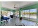 Enclosed lanai with dining and lounge area, providing a relaxing space with views of the pool and tropical landscape at 1918 Massachusetts Ave, Englewood, FL 34224