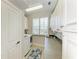 Laundry room includes washer, dryer, sink, white cabinets, and a window at 1918 Massachusetts Ave, Englewood, FL 34224
