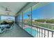 Spacious screened-in patio overlooking the pool and canal, offering a serene outdoor living space for relaxation at 1918 Massachusetts Ave, Englewood, FL 34224