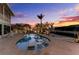 Charming kidney-shaped pool with built-in lounge chairs surrounded by lush tropical landscaping at 1918 Massachusetts Ave, Englewood, FL 34224