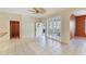 Spacious living area featuring tile flooring, lots of light, and a side door with window coverings at 2103 L Pavia Blvd # 2103, Venice, FL 34292