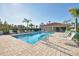 Community pool with lounge chairs on brick-paved deck on a sunny day at 2103 L Pavia Blvd # 2103, Venice, FL 34292