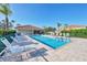 Community pool with lounge chairs on brick-paved deck with a nearby clubhouse at 2103 L Pavia Blvd # 2103, Venice, FL 34292