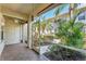 Screened-in porch with ceiling fan showcasing an outdoor view with tropical landscaping at 2103 L Pavia Blvd # 2103, Venice, FL 34292