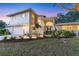 Charming two-story home with a well-manicured lawn, soft exterior lighting, and attached two-car garage at 2111 Ivory Pl, Sarasota, FL 34239