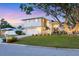 Two-story home with a well-manicured lawn, mature tree, arched window and a two-car garage at 2111 Ivory Pl, Sarasota, FL 34239