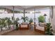 Cozy screened patio with cushioned chairs and small table, surrounded by potted plants and foliage at 2111 Ivory Pl, Sarasota, FL 34239