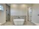 Bathroom featuring a soaking tub, tiled shower, and stone accent wall at 217 Rotonda S Blvd, Rotonda West, FL 33947