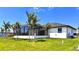 A beautiful home with lush green lawn, palm trees, and a screened-in patio at 217 Rotonda S Blvd, Rotonda West, FL 33947