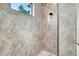 Contemporary tiled shower with rain shower head and natural light from a window at 217 Rotonda S Blvd, Rotonda West, FL 33947