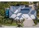 An aerial view captures the home with its geometric metal roof, verdant foliage, and private pool at 222 Willow Ave, Anna Maria, FL 34216