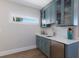 Stylish bar area with custom cabinets, wine fridge, and sleek counter at 222 Willow Ave, Anna Maria, FL 34216