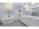 Elegant bathroom featuring a standalone tub, double vanity, and contemporary fixtures at 222 Willow Ave, Anna Maria, FL 34216