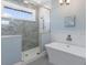 Modern bathroom with a glass-enclosed shower and sleek soaking tub for a spa-like experience at 222 Willow Ave, Anna Maria, FL 34216