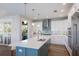 Kitchen with white cabinets, stainless steel appliances, and large island with quartz countertop at 222 Willow Ave, Anna Maria, FL 34216