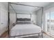 Bright main bedroom with four-poster bed, white finishes, and plantation shutters at 222 Willow Ave, Anna Maria, FL 34216