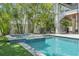 Backyard pool with a jacuzzi, patio, tropical trees and a modern staircase at 222 Willow Ave, Anna Maria, FL 34216