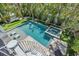 An aerial shot of an inviting pool and spa, enhanced by lush landscaping and stylish lounge chairs, with spiral staircase at 222 Willow Ave, Anna Maria, FL 34216