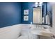 Chic powder room with stylish blue accent wall, modern fixtures and floating sink at 222 Willow Ave, Anna Maria, FL 34216