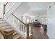 A staircase leads down to a living area with hardwood floors, plantation shutters, and a ceiling fan at 222 Willow Ave, Anna Maria, FL 34216