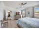 Light and airy bedroom boasts tile floors, ceiling fan, dresser with TV, and large windows at 2239 Ellarose Cir, Sarasota, FL 34232