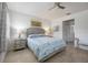 Bright bedroom features tile flooring, ceiling fan, and comfortable bed with blue patterned comforter at 2239 Ellarose Cir, Sarasota, FL 34232