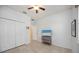 Well-lit bedroom with tile floors, ceiling fan, closet, and a dresser with mounted television at 2239 Ellarose Cir, Sarasota, FL 34232
