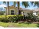 Angle view of a well-manicured home featuring lush landscaping and a charming facade at 2239 Ellarose Cir, Sarasota, FL 34232