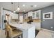 Modern kitchen island with seating, pendant lights, stainless appliances, and gray accent wall at 2239 Ellarose Cir, Sarasota, FL 34232
