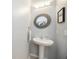 Stylish powder room with a decorative mirror and pedestal sink at 2239 Ellarose Cir, Sarasota, FL 34232