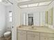 Well-lit bathroom with a large vanity, a generous mirror, and a toilet at 2271 Pine View Cir, Sarasota, FL 34231