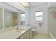 Well-lit bathroom with a large mirror, tiled floors, and neutral-tone fixtures at 2271 Pine View Cir, Sarasota, FL 34231