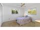 Cozy bedroom with a ceiling fan, carpet floors, and natural light from two windows at 2271 Pine View Cir, Sarasota, FL 34231