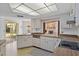Open kitchen with white cabinets and appliances, offering a view of the backyard at 2271 Pine View Cir, Sarasota, FL 34231