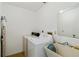 Laundry room features a washer, dryer, utility sink, and shelving at 2271 Pine View Cir, Sarasota, FL 34231