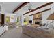 Open-concept living room features wood beams and a cozy stone fireplace at 2271 Pine View Cir, Sarasota, FL 34231