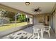Relaxing screened patio with ceiling fan, offering views of the lush backyard and a glimpse of the kitchen at 2271 Pine View Cir, Sarasota, FL 34231
