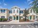 Charming townhome featuring a well-manicured lawn, vibrant green doors, and a welcoming front porch at 238 Cape Harbour Loop # 104, Bradenton, FL 34212