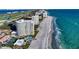 Stunning aerial view of beachfront condos with a pool and tennis courts providing resort-style amenities and ocean views at 2525 Gulf Of Mexico Dr # 3F, Longboat Key, FL 34228