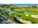 Scenic aerial view of golf course community with water features, lush greens, and waterfront access, offering a serene retreat at 2525 Gulf Of Mexico Dr # 3F, Longboat Key, FL 34228